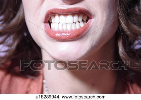 Picture - Close up of woman baring her teeth, face detail. Fotosearch