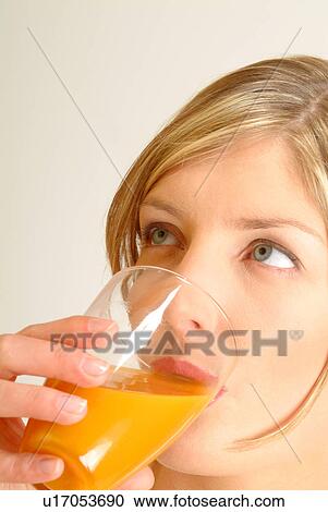 Stock Image - Close-up of Woman drinking juice. Fotosearch