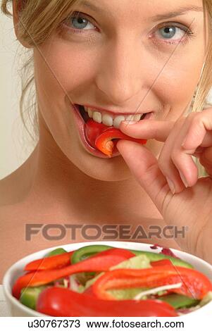 Close-up of Woman eating red pepper View Large Photo Image Stock Image - Close-up of Woman eating red pepper. Fotosearch