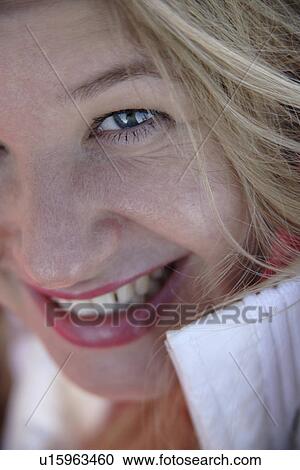 Stock Image - Portrait of young blond woman smiling, close up. Fotosearch
