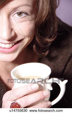 Young brunette woman holding cup of coffee, close up View Large Photo Image Stock Image - Young brunette woman holding cup of coffee, close up. Fotosearch