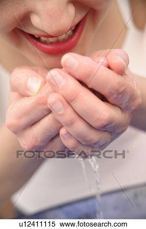 Young woman drinking water from her hands, close up View Large Photo Image Stock Photography - Young woman drinking water from her hands, close up. Fotosearch