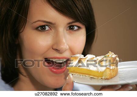 Young woman eating slice of fruit pie, portrait, close up View Large Photo Image Stock Image - Young woman eating slice of fruit pie, portrait, close up. Fotosearch