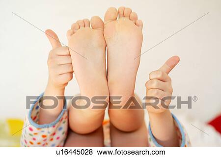 Girl Showing Soles Of Her Feet And Hands With Thumbs Up Girl Showing Soles Of Her Feet And Hands With Thumbs Up