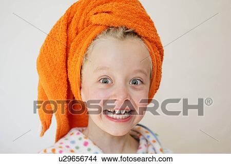 Picture - Girl wearing bathrobe and towel around hair, looking scared. Fotosearch