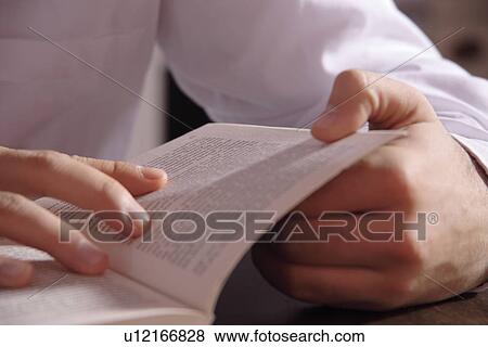 Young man reading a book, close up of hands holding the pages View Large Photo Image Stock Photo - Young man reading a book, close up of hands holding the pages. Fotosearch