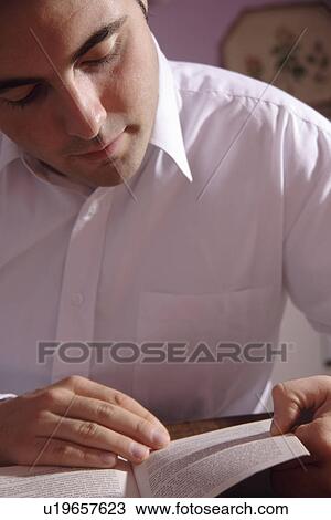 Stock Image - Young man reading a book. Fotosearch