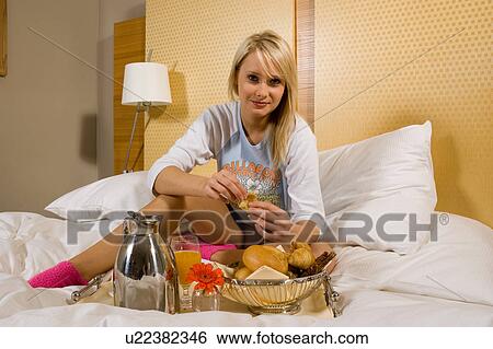 Young girl having breakfast in bed in her pajamas View Large Photo Image Stock Photograph - Young girl having breakfast in bed in her pajamas. Fotosearch