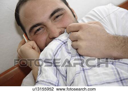 Young man in bed pulling the blanket up to his chin, close up View Large Photo Image Stock Image - Young man in bed pulling the blanket up to his chin, close up. Fotosearch
