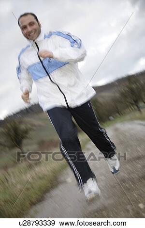 Young man jogging in spite of bad weather View Large Photo Image Stock Photo - Young man jogging in spite of bad weather. Fotosearch
