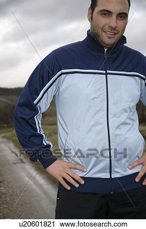 Young man jogging in sportswear, three quarter length View Large Photo Image Stock Image - Young man jogging in sportswear, three quarter length. Fotosearch