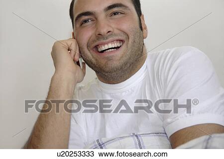 Young man sitting in bed, laughing View Large Photo Image Stock Image - Young man sitting in bed, laughing. Fotosearch