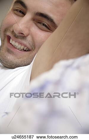 Young man stretching on bed, smiling View Large Photo Image Stock Photo - Young man stretching on bed, smiling. Fotosearch