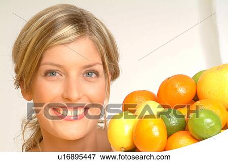 Stock Photo - Portrait of Woman with bowl of citrus fruit. Fotosearch