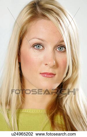 Stock Image - Portrait of young business woman with long blond hair wearing green sweater. Fotosearch
