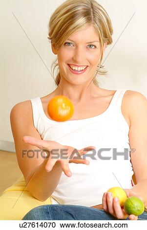 Woman tossing orange View Large Photo Image Stock Image - Woman tossing orange. Fotosearch