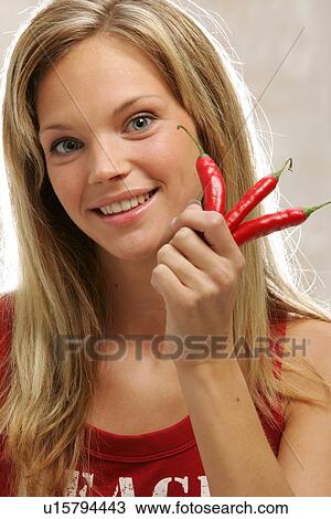 Young woman with long blond hair holding three chili peppers, portrait View Large Photo Image Stock Image - Young woman with long blond hair holding three chili peppers, portrait. Fotosearch