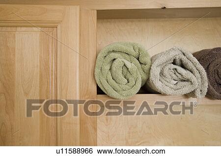 Three towels rolled and arranged on a wooden shelf View Large Photo Image Stock Photograph - Three towels rolled and arranged on a wooden shelf. Fotosearch