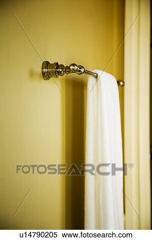 Stock Photography - White Towel Hanging on Towel Bar on Yellow Wall. Fotosearch