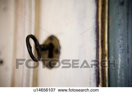 Stock Photo - Aged key in keyhole. Fotosearch