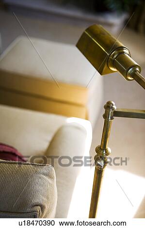 Stock Image - Brass Reading Lamp next to White Sofa. Fotosearch