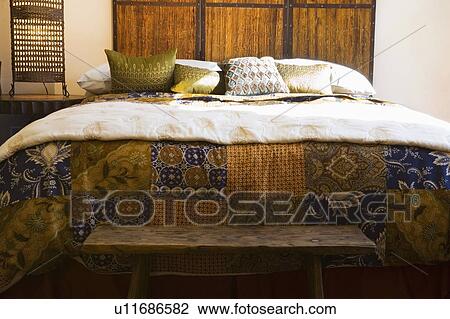 Stock Image - Patterned Quilt on Cozy Bed. Fotosearch