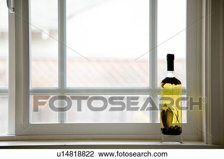 Stock Image - Bottle of cooking oil on windowsill. Fotosearch