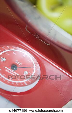 Stock Photograph - Green apples on kitchen scale, close up. Fotosearch