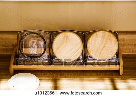 Stock Image - Three Square Glass Jars with Round Wood Lids. Fotosearch