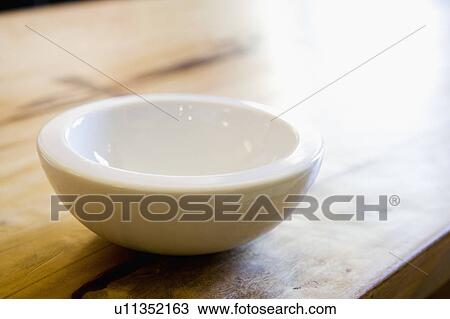 Stock Image - White Bowl on Wood Table. Fotosearch
