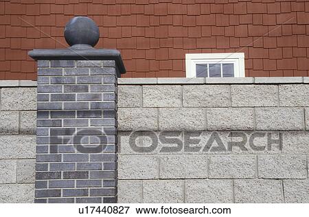 Stock Photo - Brick Wall in Front of Red House. Fotosearch