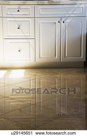 Stock Image - Cabinets reflecting in tile. Fotosearch