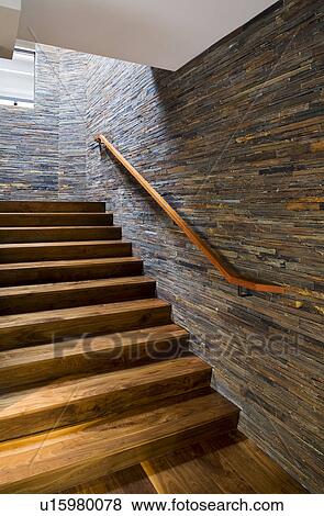 Stock Photo - Hardwood Staircase with Stone Tile Wall. Fotosearch