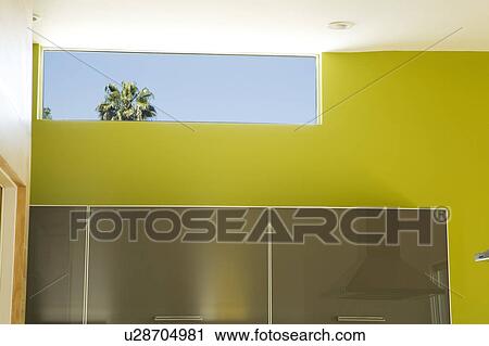 Stock Image - Modern kitchen cabinets and green wall. Fotosearch