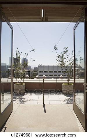 Stock Image - View of city through double glass doors.. Fotosearch