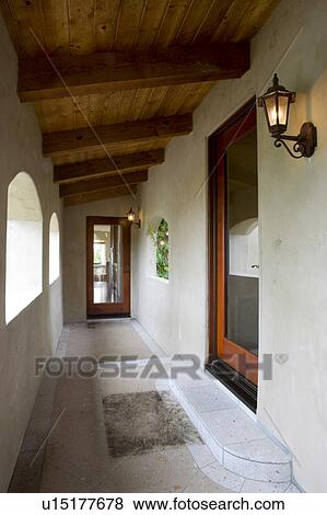 Stock Photo - Vignette of hallway with wood door, arches and llights.. Fotosearch
