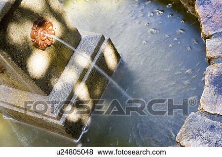Stock Photo - Rock fountain in Spanish style courtyard. Fotosearch