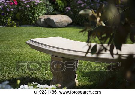 Stone Bench In Yard With Garden Stock Photograph U19231786