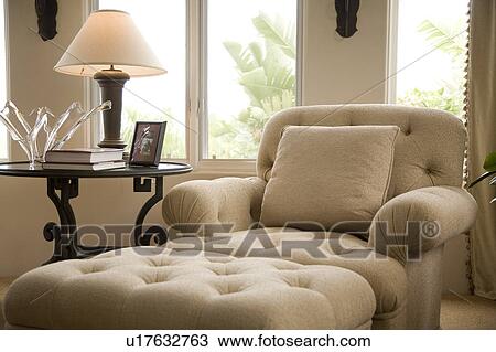 Stock Image - Detail of and chaise longue with lamp and table.. Fotosearch