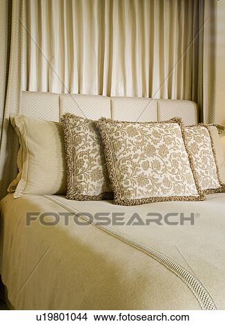 Picture - Detail of neutral toned decorative pillows on bed.. Fotosearch