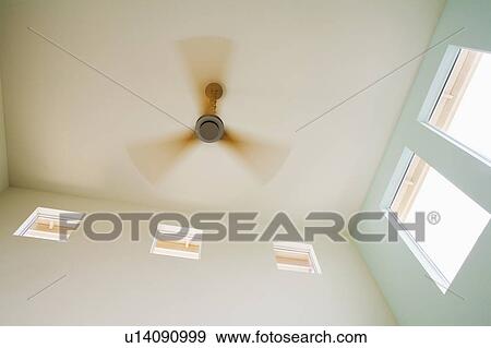 Stock Photo - Modern Ceiling Fan with Wood Blades in Motion. Fotosearch