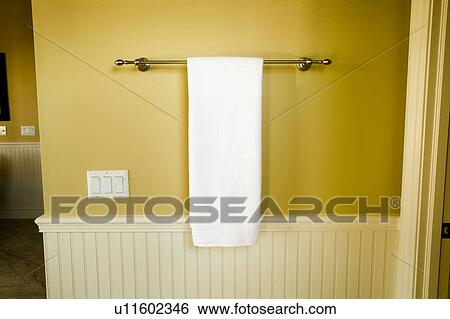 Stock Photograph - White Towel, Towel Bar, and Yellow Bathroom Wall. Fotosearch