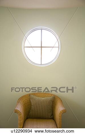 Picture - Wicker chair and circle window. Fotosearch
