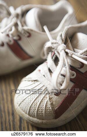 Stock Photograph - Detail of kids sneakers on hardwood floor. Fotosearch