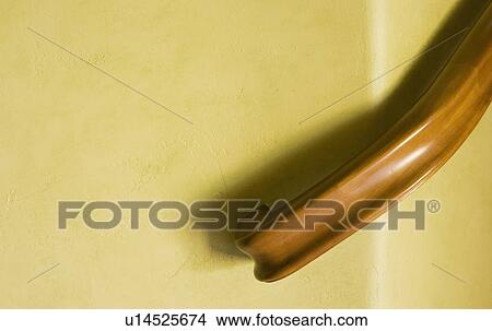 Picture - Detail of staircase railing on yellow wall. Fotosearch