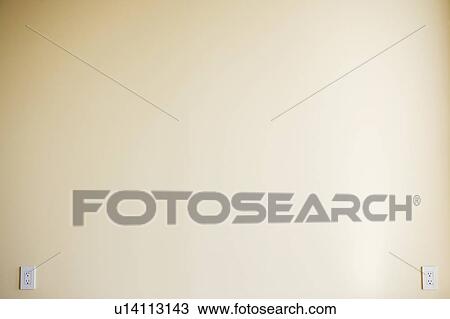 Stock Image - Two electric outlets on yellow wall. Fotosearch