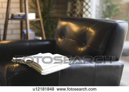 Detail of an open book resting on a leather arm chair View Large Photo Image Stock Photo - Detail of an open book resting on a leather arm chair. Fotosearch