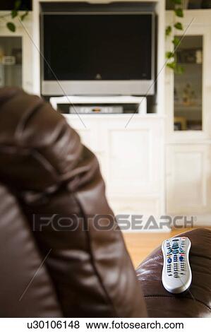 Television remote on arm of leather chair View Large Photo Image Stock Photo - Television remote on arm of leather chair. Fotosearch