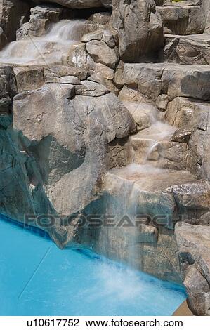Rock waterfall to swimming pool View Large Photo Image Stock Image - Rock waterfall to swimming pool. Fotosearch
