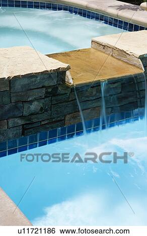 Waterfall from jacuzzi to swimming pool View Large Photo Image Stock Photograph - Waterfall from jacuzzi to swimming pool. Fotosearch